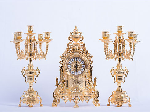 Набор из бронзовых часов и 2 подсвечников, выполненный в золотистом цвете. Производство Италии. 